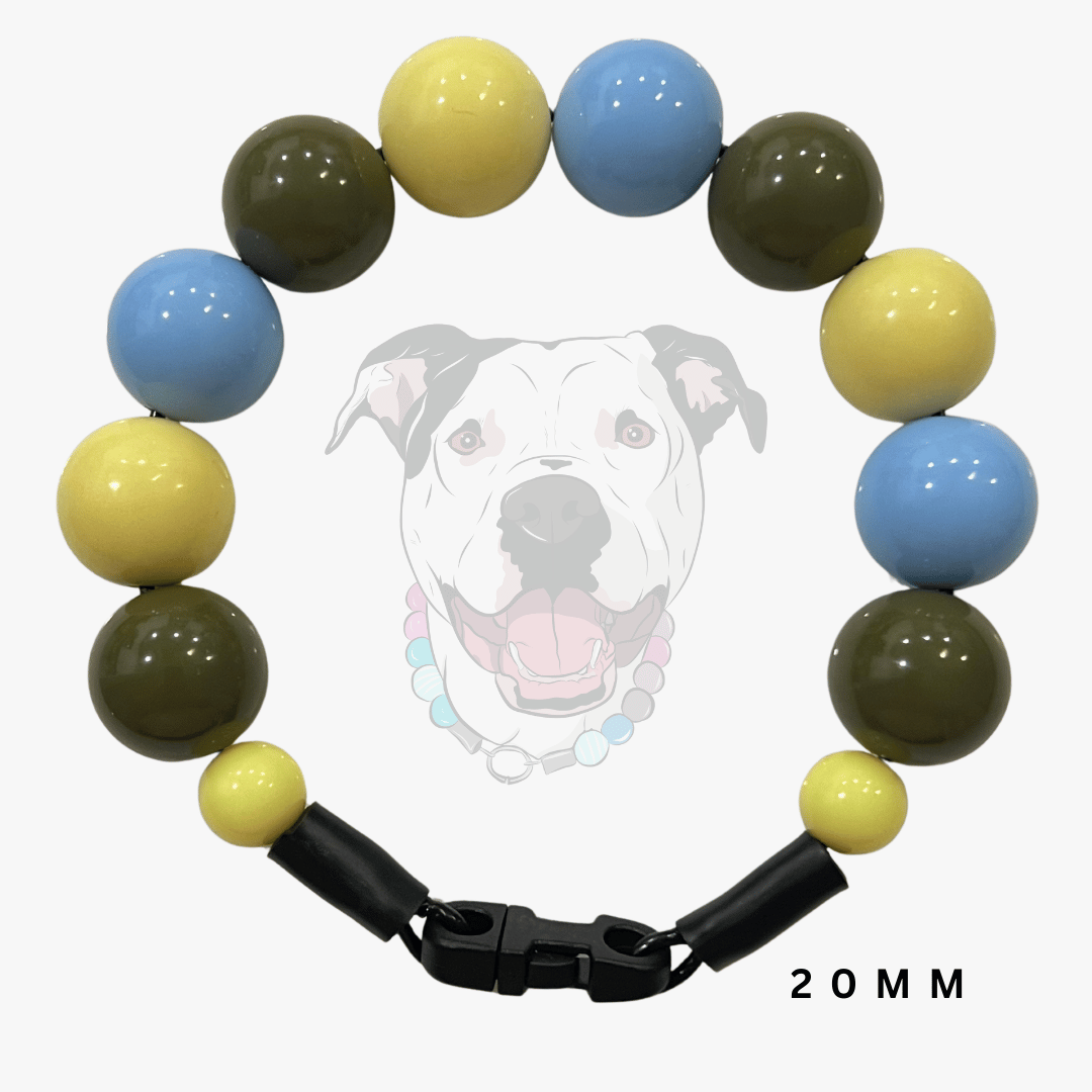 A beaded dog collar with alternating light blue, yellow, and olive green round beads, finished with a black quick-release clasp. A faint graphic of a happy dog wearing the collar is visible in the background, with '20MM' text printed in the bottom right corner.