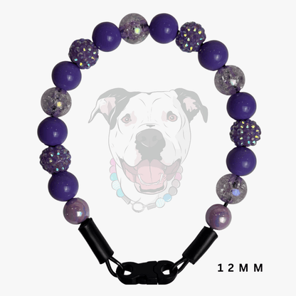 A beaded dog collar shown on a light gray background with a faint dog graphic behind it. The collar features purple beads, glittery clear beads, and black clasp hardware.