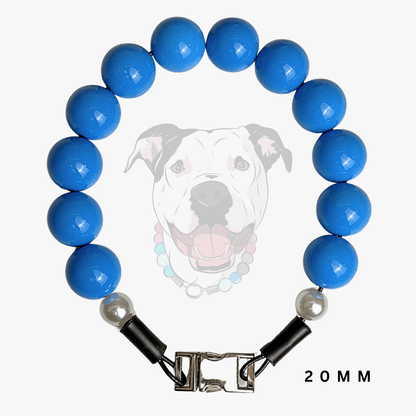A beaded dog collar featuring glossy blue round beads, a silver-toned metal clasp, and two small white pearl-like accent beads. A faint graphic of a dog wearing the collar is displayed in the background, with '20 MM' text in the bottom right corner.