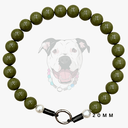 A dog collar made of glossy olive green round beads, featuring a black metal ring clasp with white pearl-like accents. A faint graphic of a dog wearing the collar is displayed in the background, with '20MM' text on the bottom right.