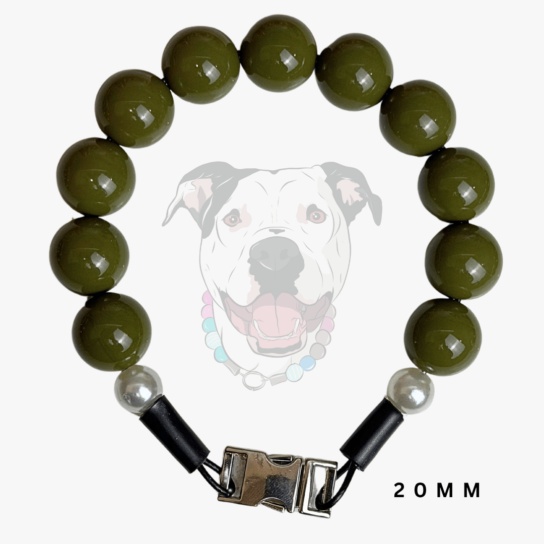 A beaded dog collar featuring glossy olive green round beads, a white pearl accent, black end caps, and a silver metal buckle. A faint graphic of a dog wearing the collar is displayed in the background, with '20MM' text in the bottom right corner.