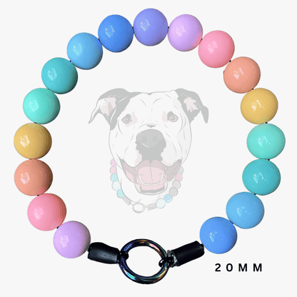 A pastel beaded dog collar arranged in a circle on a light gray background, featuring a faded dog face graphic in the center and a black toggle clasp at the bottom. The beads are in pink, blue, purple, teal, yellow, and peach, with '20MM' text in the lower right.