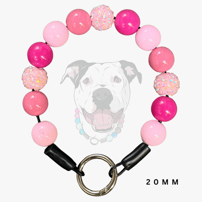 A pink beaded dog collar with a metal ring clasp, shown against a light gray background with a faint dog graphic and the text '20MM'.