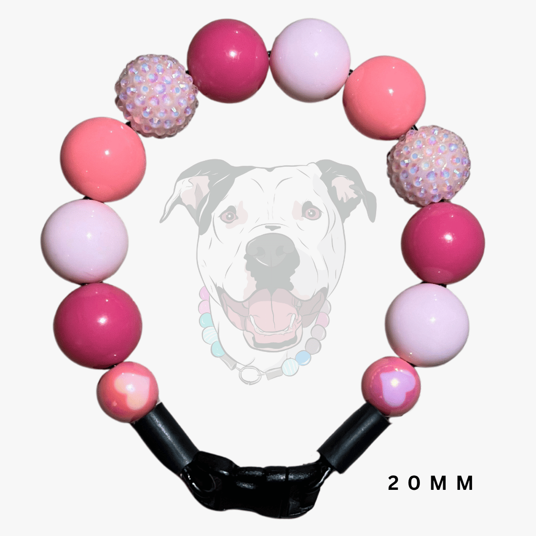 A pink beaded dog collar with alternating smooth round beads and two textured, sparkly iridescent beads, featuring a black plastic clasp. A faint graphic of a dog wearing the collar is visible in the background, with '20MM' text in the bottom right corner.