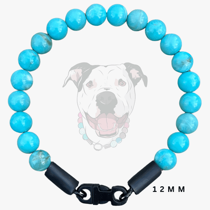 A pet collar made of turquoise-blue marbled beads with black end caps and a black clasp, shown on a light gray background with a faint dog illustration and the text '12 MM'.