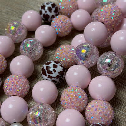 Close up of POPNCO handcrafted beaded pet collars Jolene laying flat on a white background featuring pale pink solid, crackle and rhinestone bayberries mixed with brown cow print beads. 
