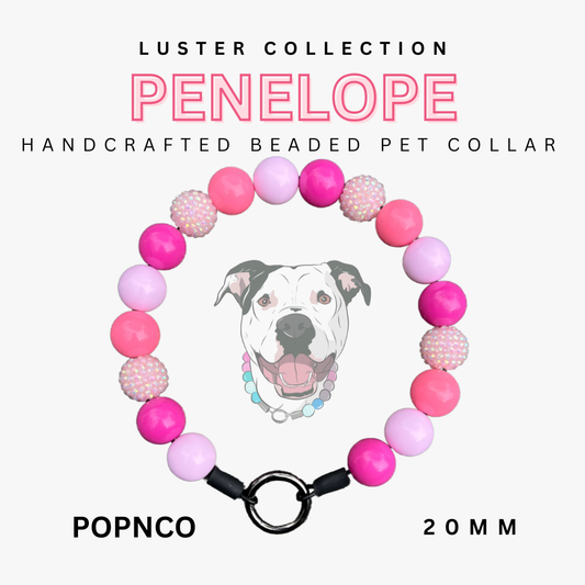 Handcrafted beaded pet collar with pink and purple beads and a black clasp, featuring the brand 'Luster Collection' and 'PENELLOPE'.