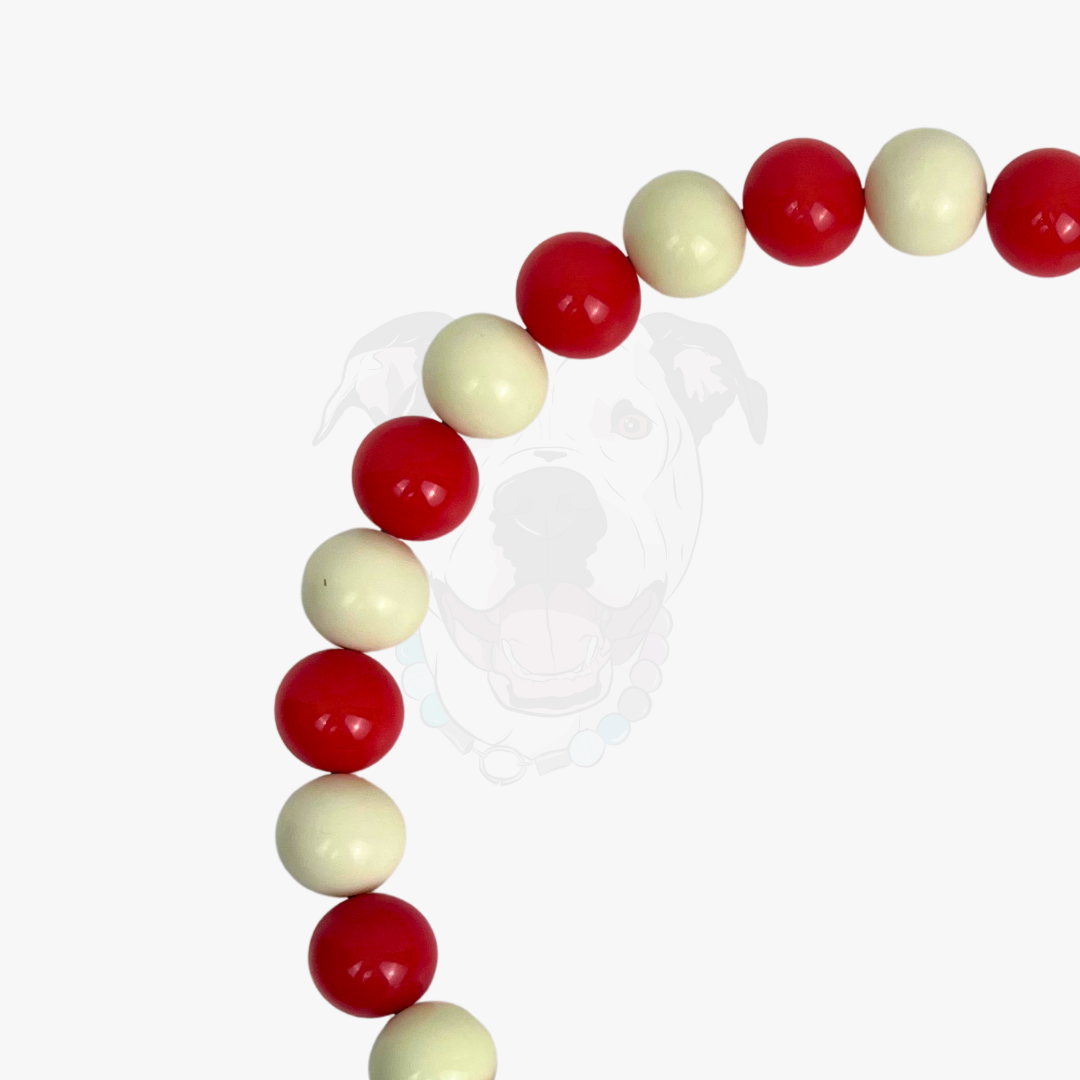 Beaded bracelet with red and beige beads on a white background