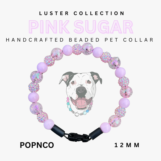 Handcrafted beaded pet collar with pink and black design, featuring a dog illustration, on a white background. Brand 'Luster Collection' and product name 'Pink Sugar' are displayed.