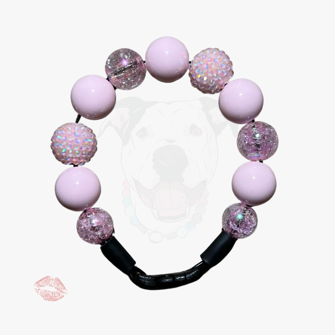 Pink beaded bracelet with glittery accents on a white background