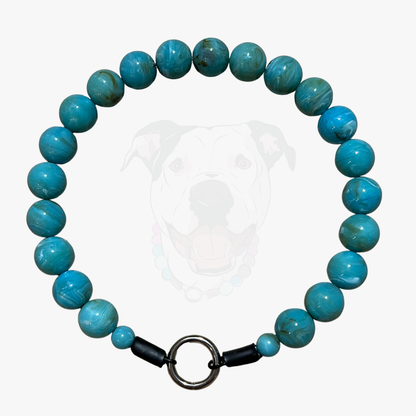 Turquoise beaded bracelet with a black clasp on a white background