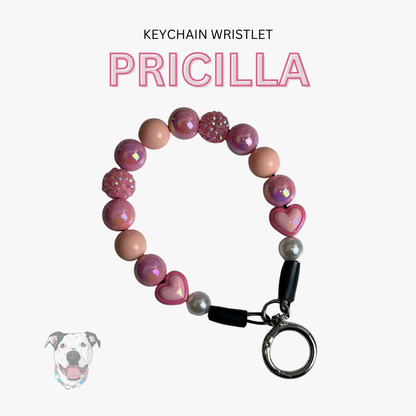 Pink and beige keychain wristlet with heart-shaped beads on a white background
