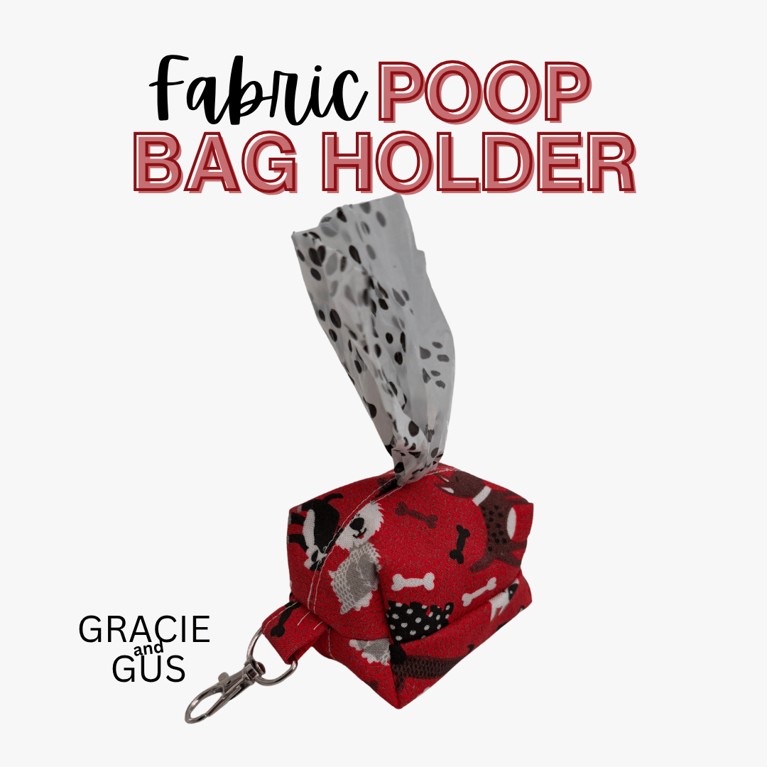 A fabric poop bag holder keychain shown on a light gray background with text reading 'Fabric POOP BAG HOLDER' and 'GRACIE and GUS'. The holder is red with black and white dog bone and spot patterns, and a gray-and-white spotted tissue pullout is visible at the top.