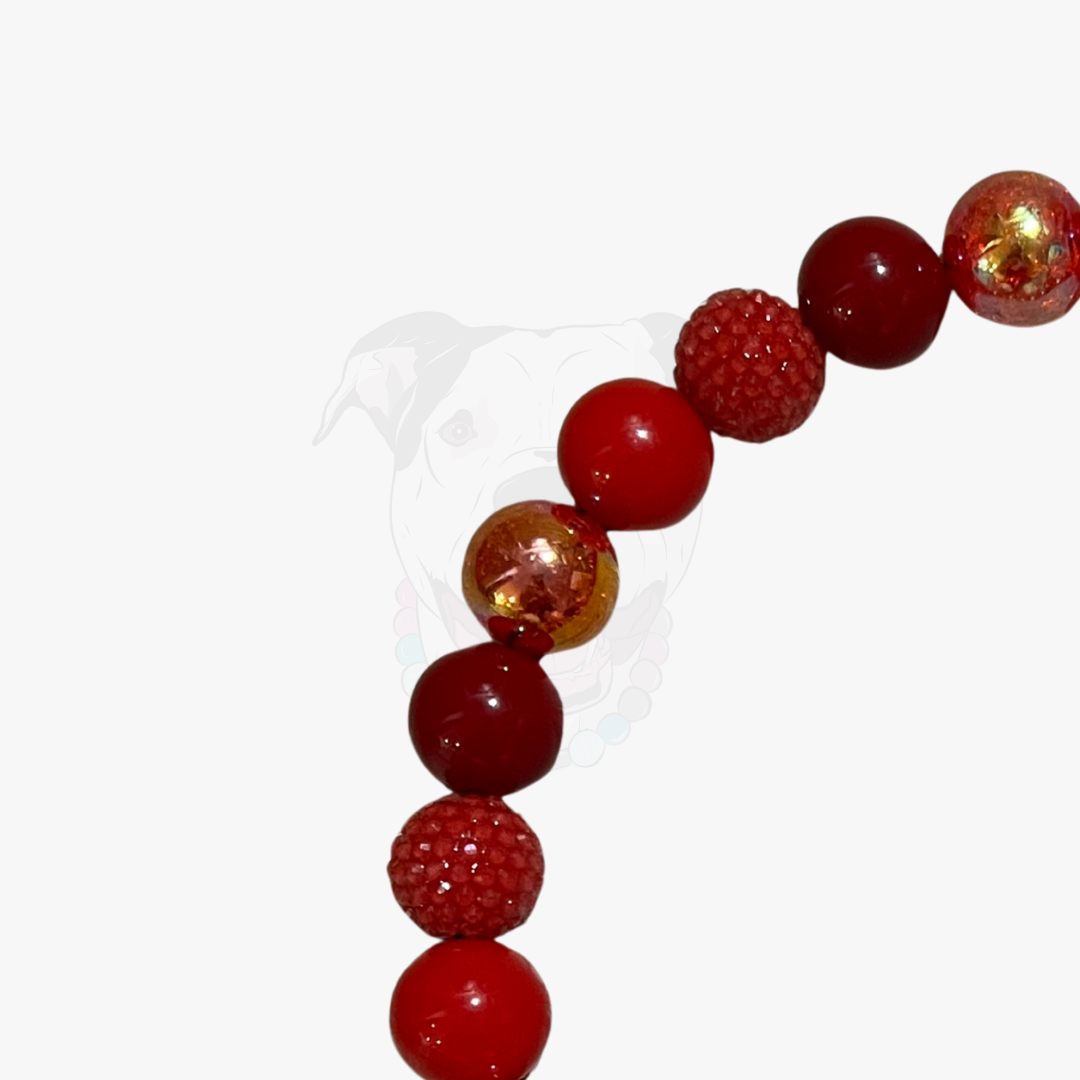 Beaded bracelet with red and gold beads on a white background