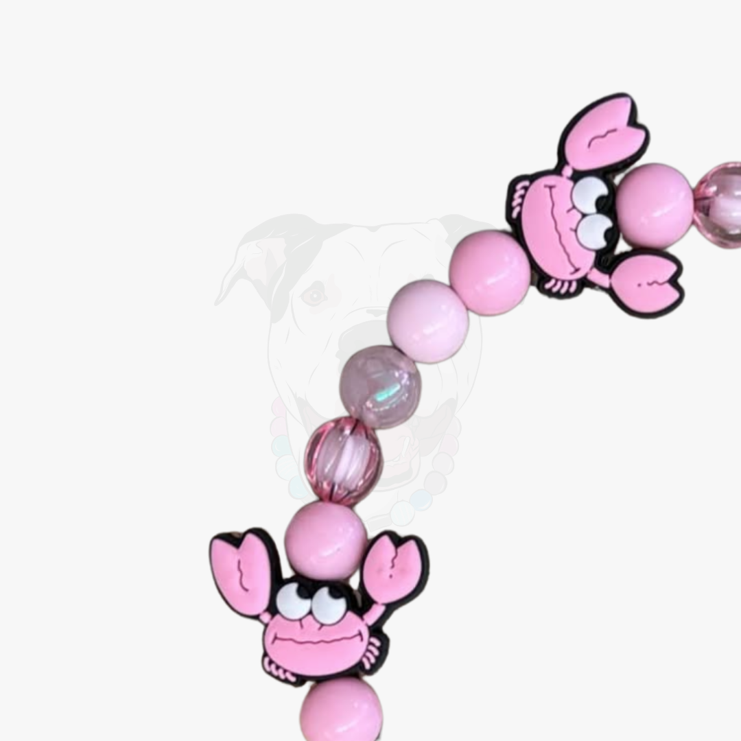 Pink beaded bracelet with cartoon lobster charms on a white background