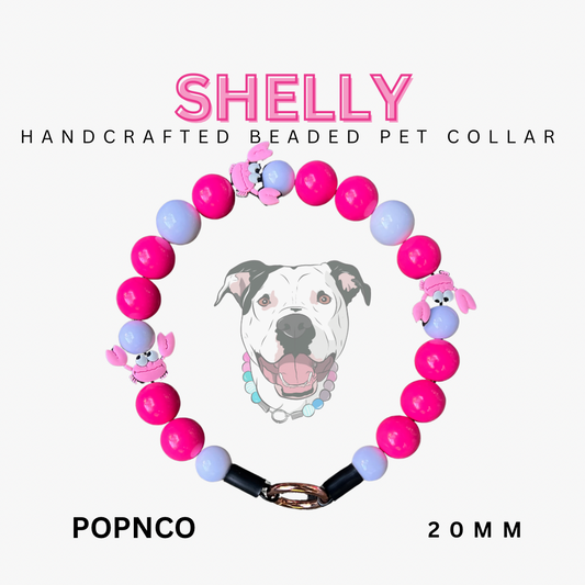 Handcrafted beaded pet collar with pink and purple beads, featuring a dog illustration and brand name 'Shelly'.