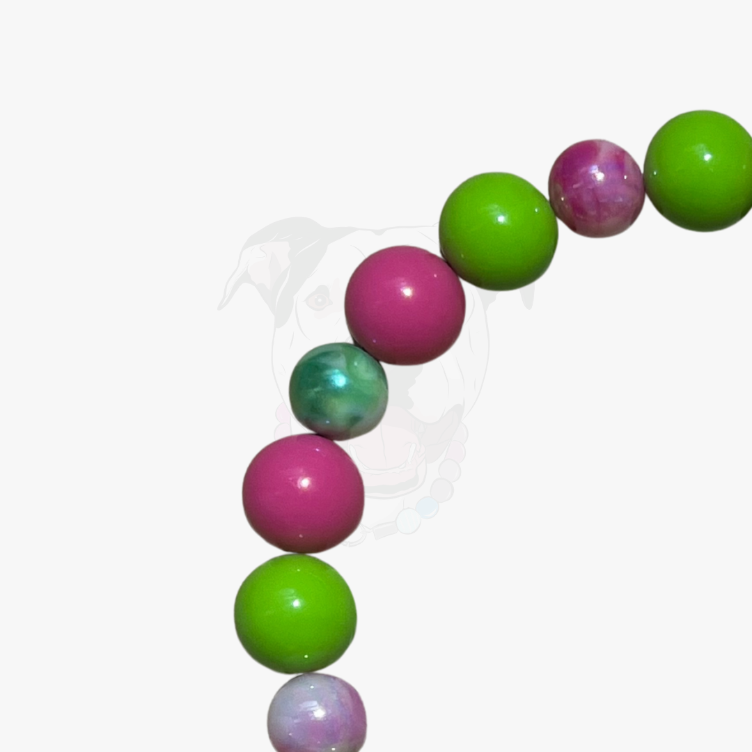 Beaded bracelet with green and pink beads on a white background