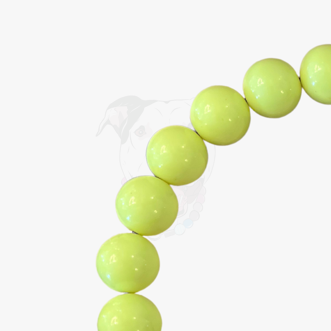 Neon green bubblegum beads on a clear string against a white background POPNCO