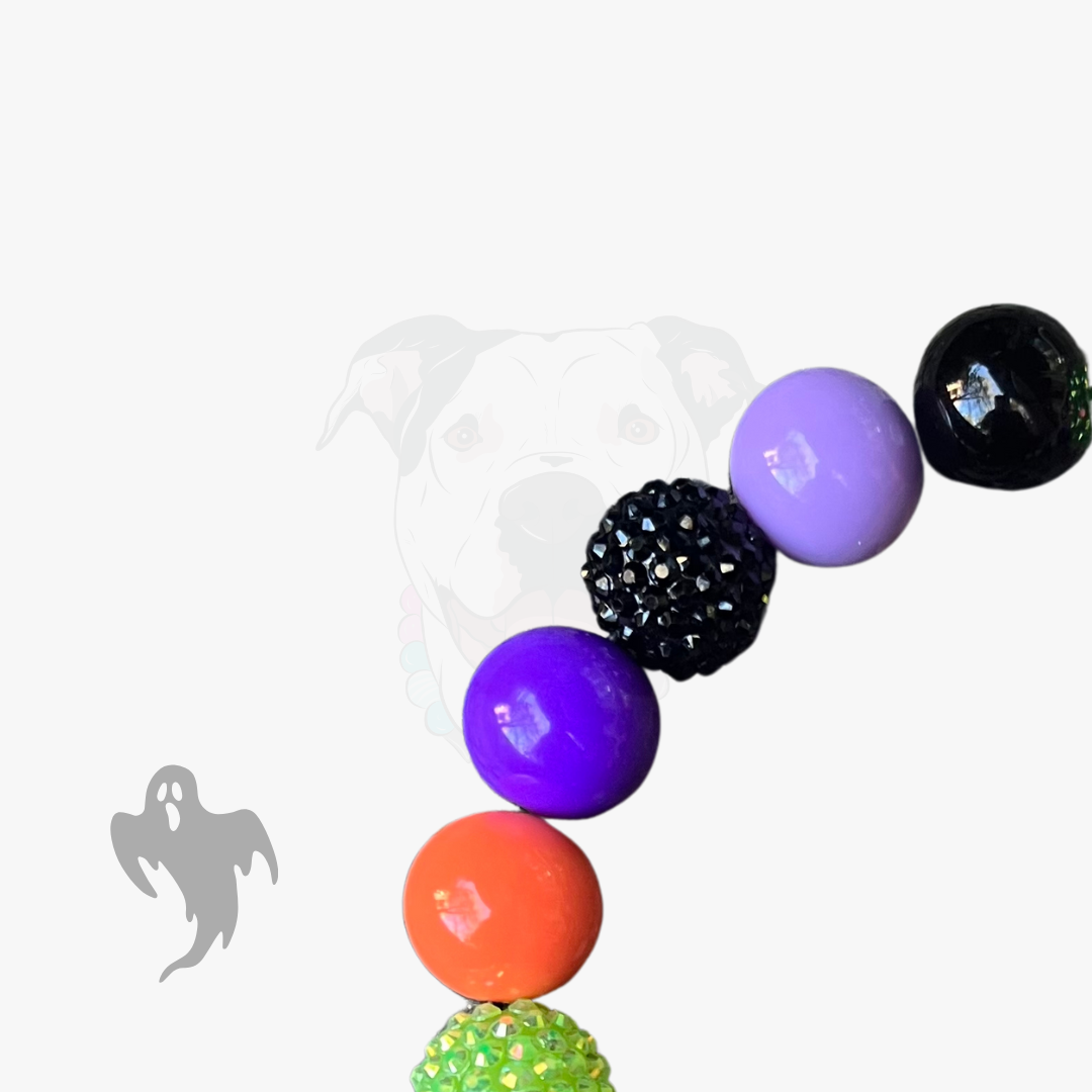 Colorful beaded necklace with purple, black, orange, and green beads on a white background.