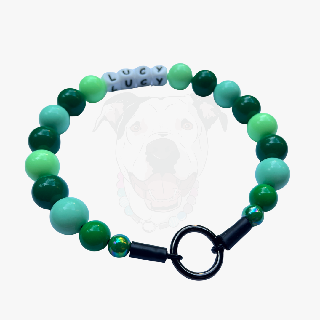 Green and teal beaded bracelet with a black clasp on a white background