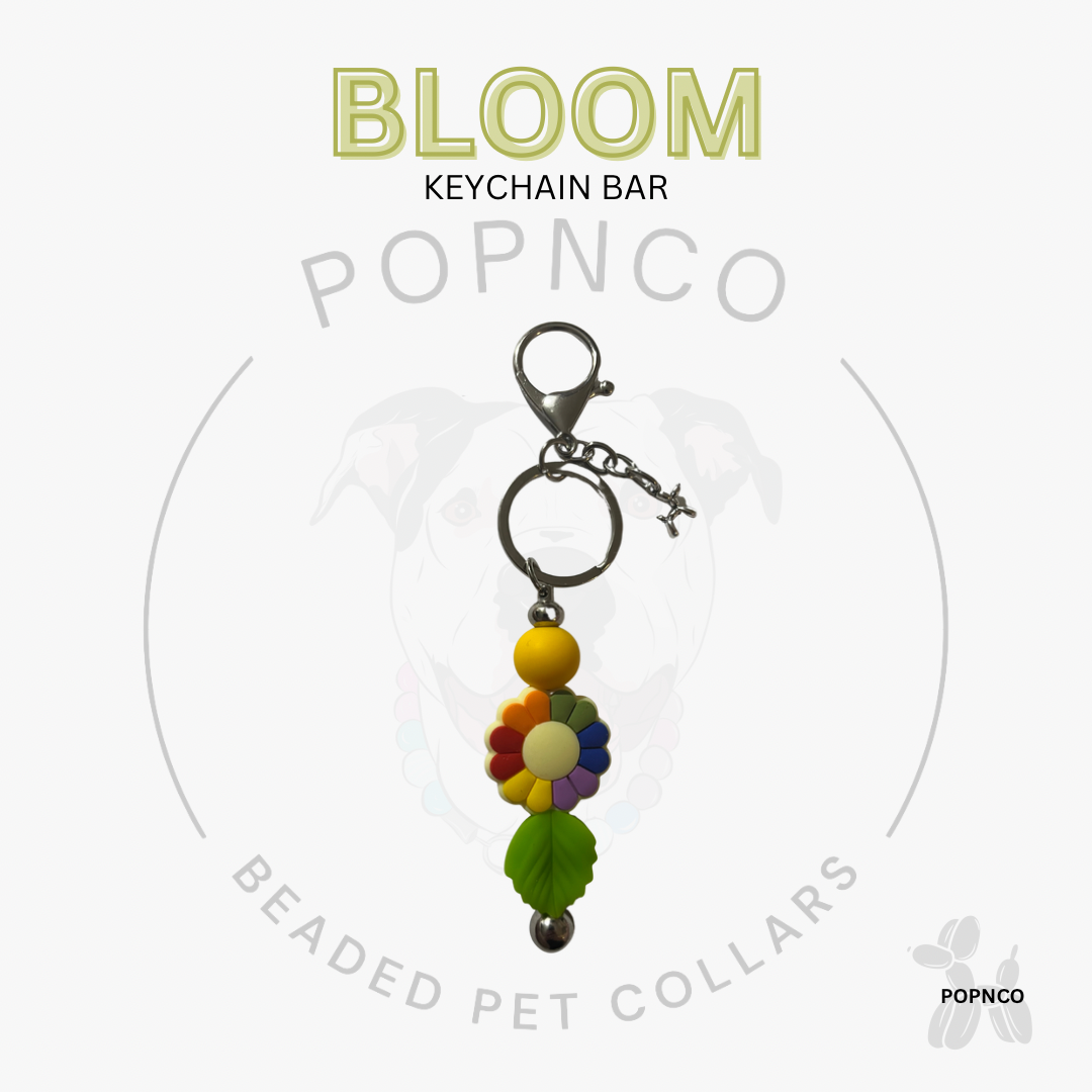 Colorful beaded keychain bar with 'BLOOM' text on a white background