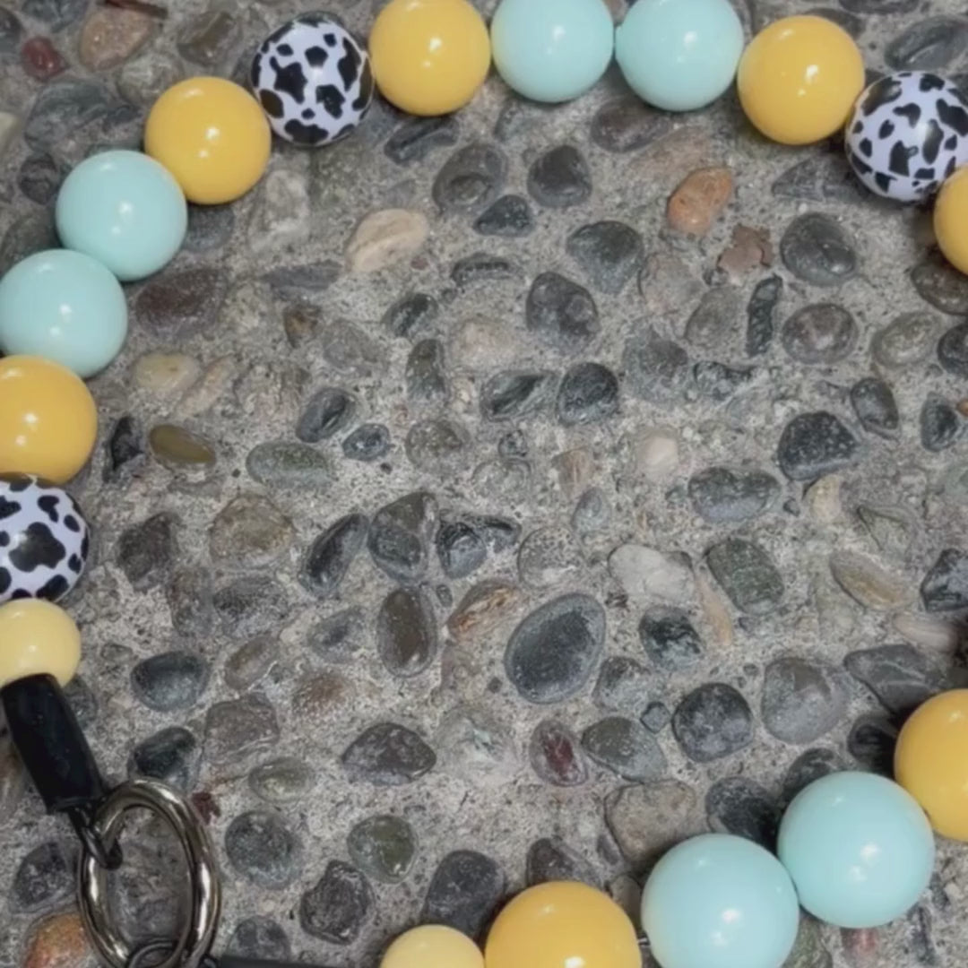 Video of POPNCO Bonnie Beaded Pet Collar Blue and  Yellow Cow 20mm, featuring yellow light blue and black and white cow print acrylic beads. 