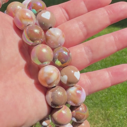 Video of the Ned and Indulgence POPNCO beaded pet collar. The Beaded Collar is crafted on aircraft grade stainless steel wire and the waterproof beads are AB Shiny iridescent shades of brown in a alternating pattern mixed with double sided brown and cream hearts. 
