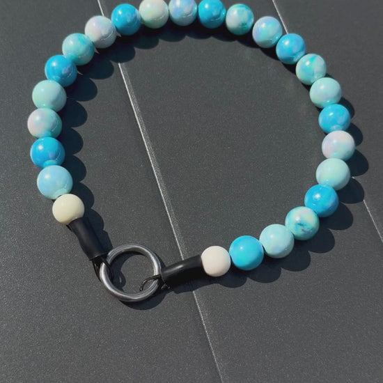 Close up of The Nelson beaded dog collar by POPNCO, featuring bright, iridescent AB acrylic beads that shimmer in the light, strung on heavy-duty cable.