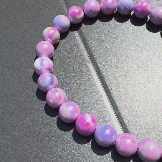 Video of Purple beaded dog collar with a black clasp called Zara on a gray surface from POPNCO