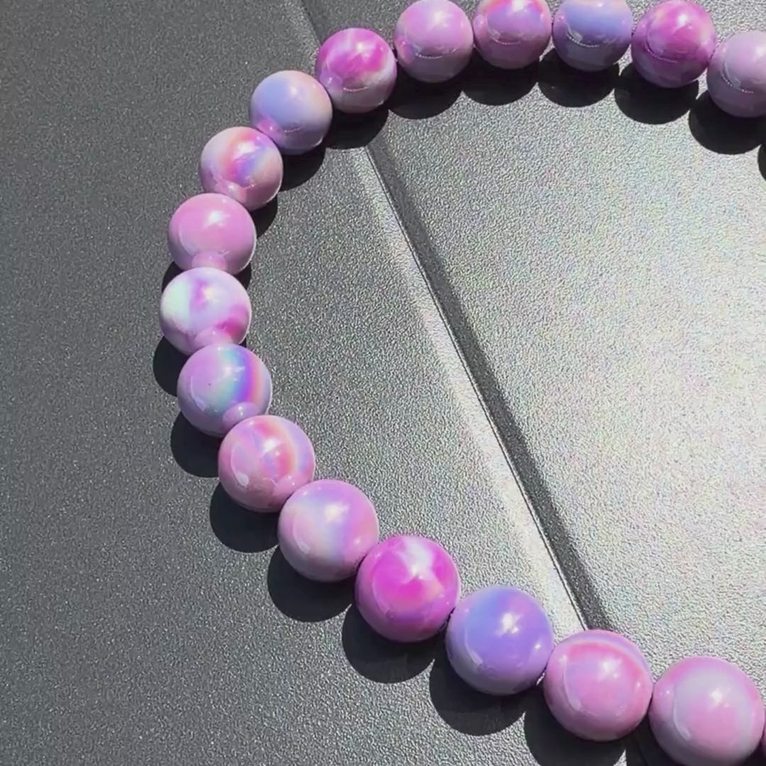 Video of Purple beaded dog collar with a black clasp called Zara on a gray surface from POPNCO