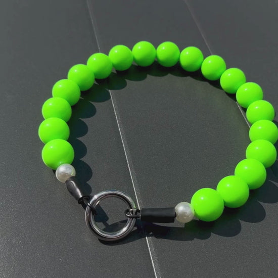 Neon Green beaded pet collar called Viper laying flat on a gray surface