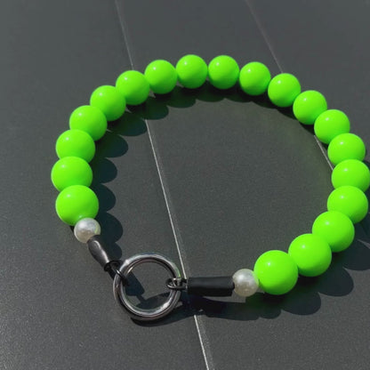 Neon Green beaded pet collar called Viper laying flat on a gray surface