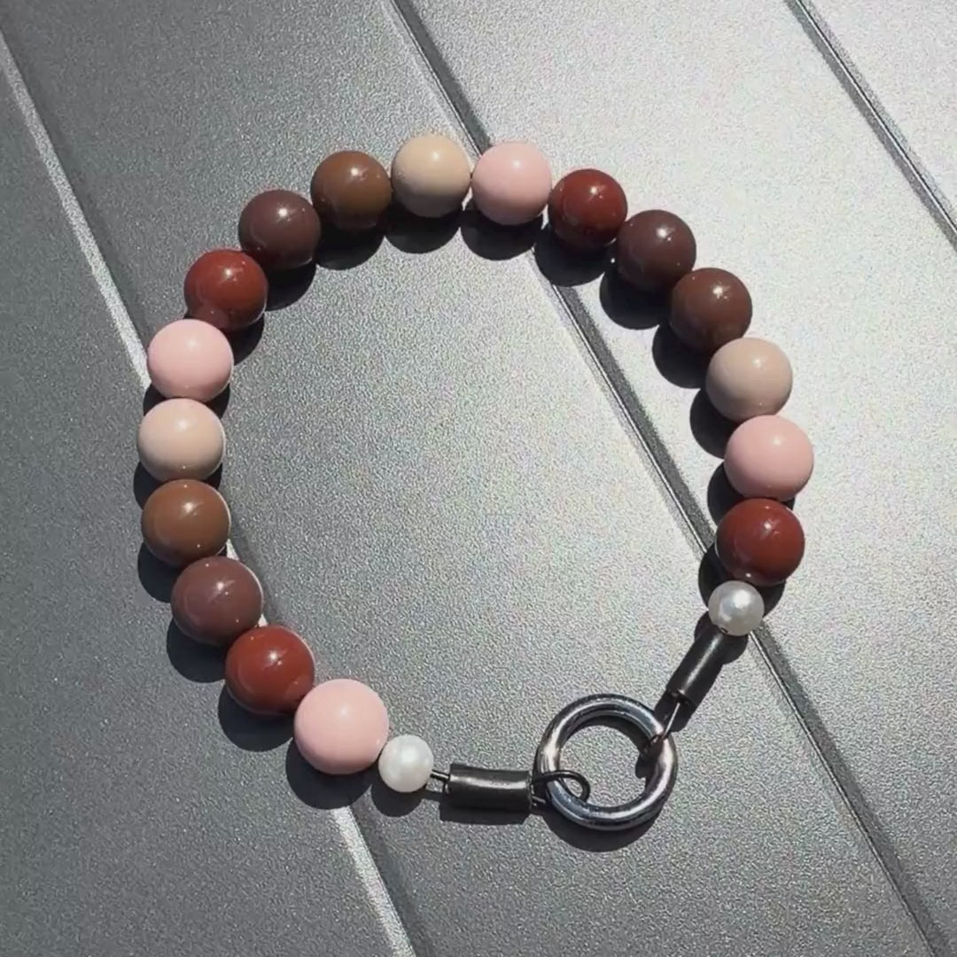 Video of Brown beaded pet collar named POPNCO on a grey table. 