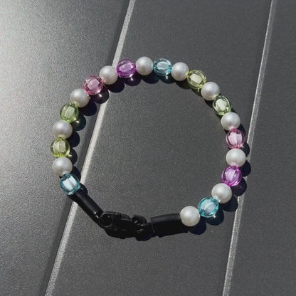 Video of Rainbow Theme Beaded pet Collar from POPNCO featuring 12mm beads alternating Blue, yellow, green, pink, purple faceted beads alternating with acrylic pearls laying flat on a black table. 